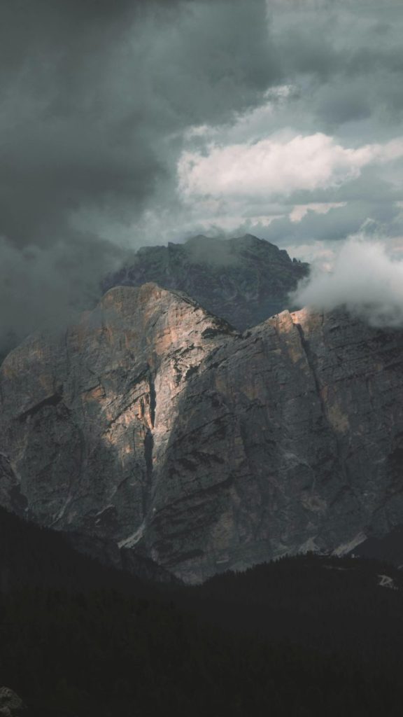 Captivating view of rugged mountain peaks partially shrouded in clouds at Cortina d'Ampezzo, Italy.